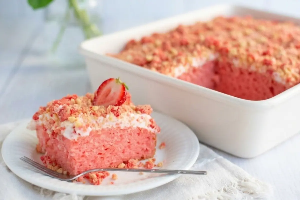 Storage Tips Tips For Your Strawberry Crunch Cake A delicious slice of strawberry crunch cake served on a white plate with a fork next to a baking dish, capturing storage tips for freshness.