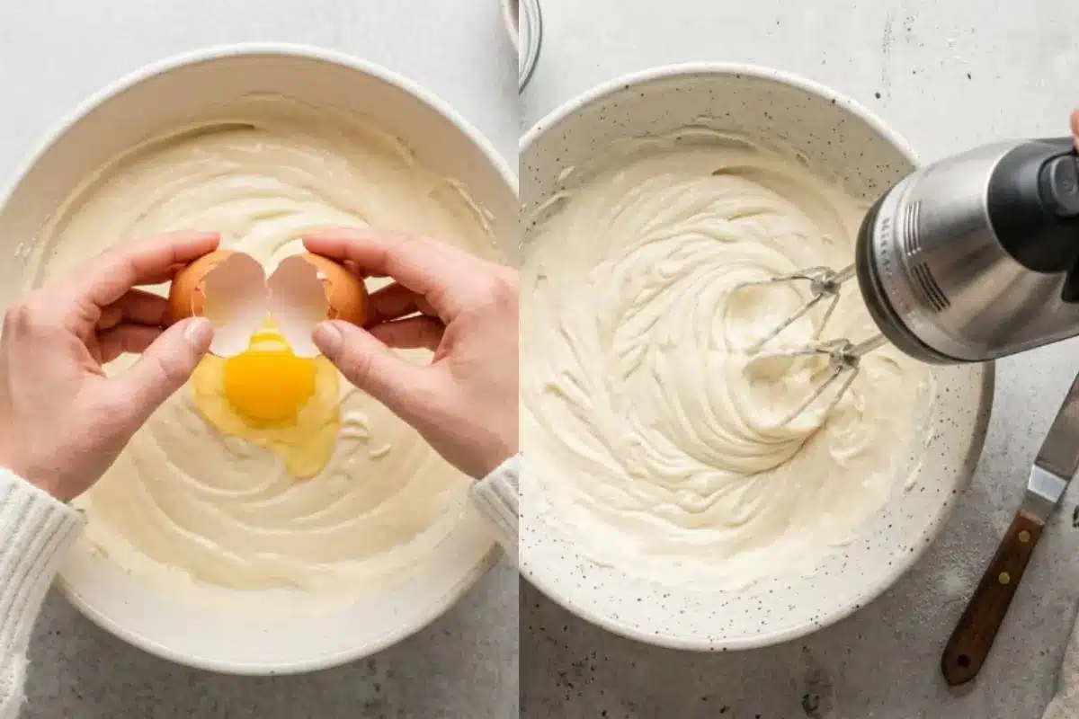 Why This Chocolate Chip Cheesecake Works An overhead static angle of hands cracking an egg into a rich cream cheese batter in a ceramic bowl, followed by a hand using a hand mixer to blend the filling on a light-grey textured concrete backdrop for a chocolate chip cheesecake.