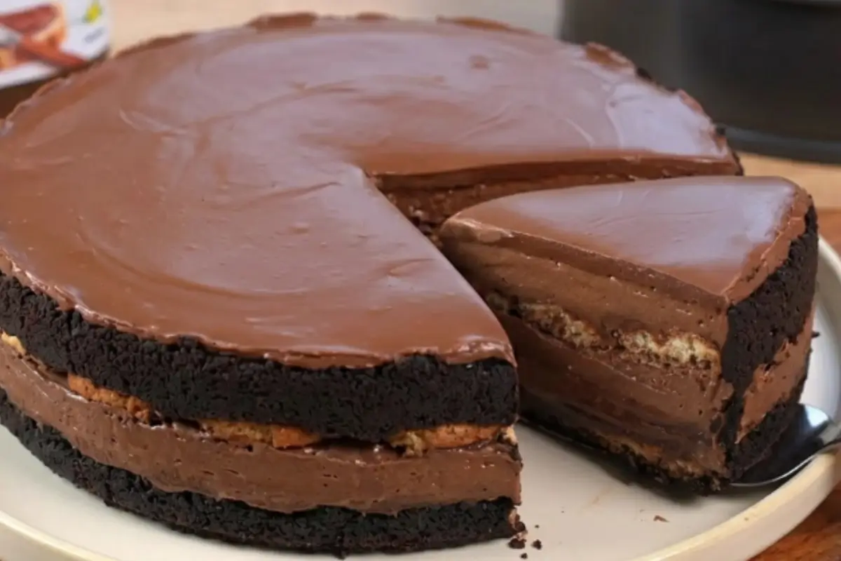 Nutella Tiramisu Cake 3 A decadent slice being served from a rich Nutella tiramisu cake, revealing beautiful layers of dark sponge, creamy mascarpone, and espresso-soaked ladyfingers on a warm, rustic ceramic plate.